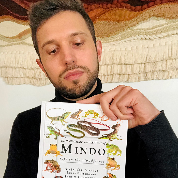 Alejandro Arteaga holds the Amphibians and Reptiles of Mindo book